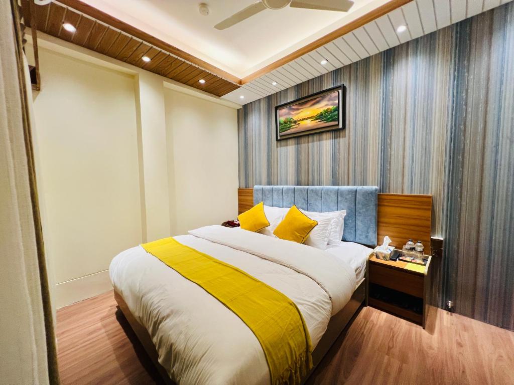 Maulvi BāzārTaj Metro的一间卧室配有一张带黄白色床单的大床