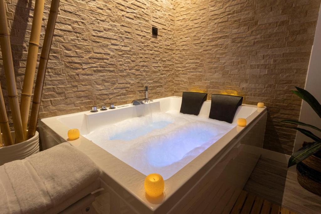 Burguillos de ToledoHuellas de la Mancha的带浴缸的浴室和石墙