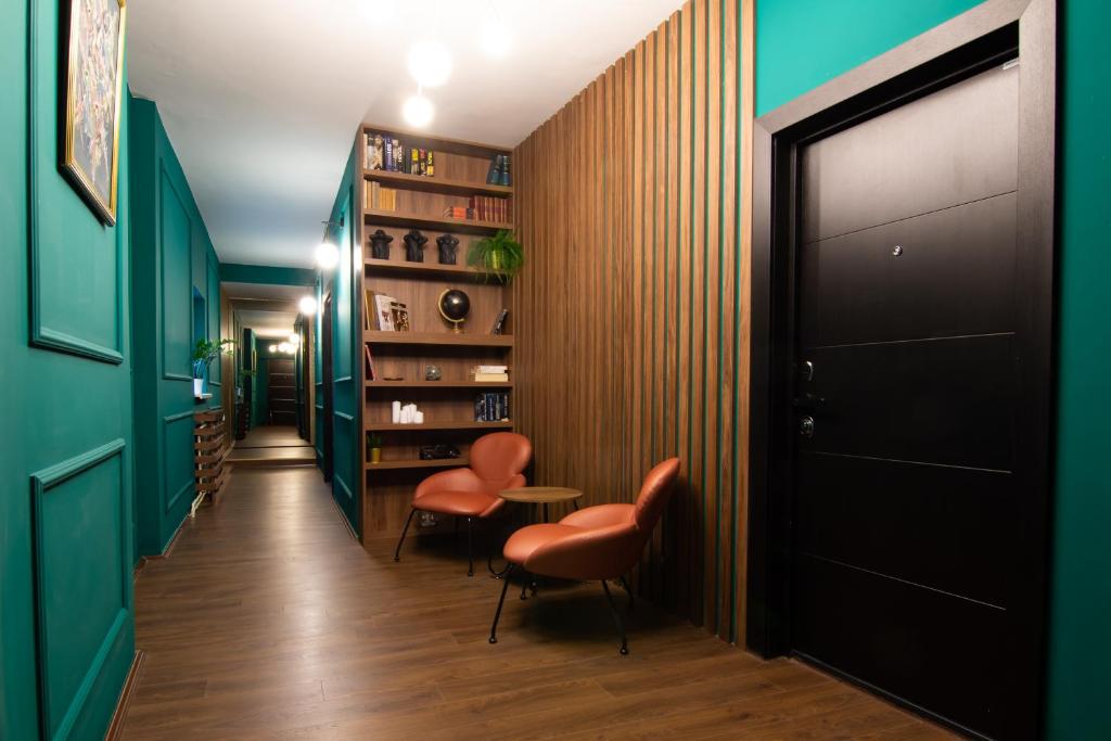 贝尔格莱德Square 6的走廊上设有绿色的墙壁、橙色的椅子和黑色的门