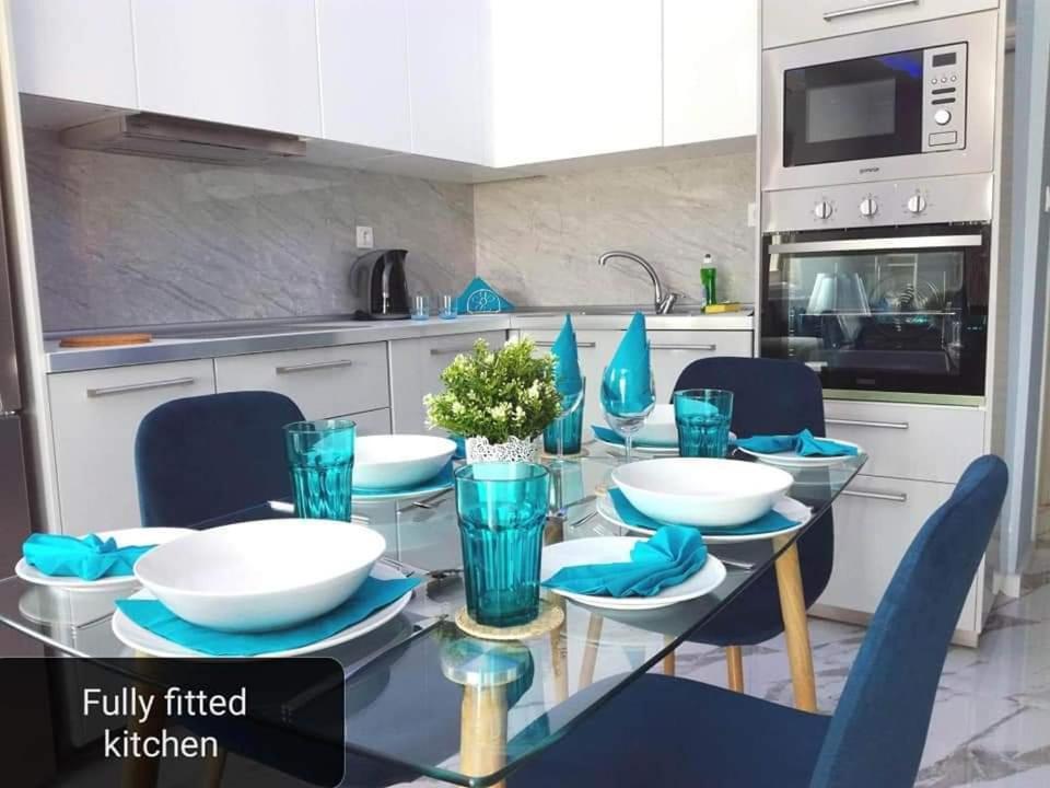 克里皮吉Villa Casagrande的厨房配有玻璃桌和蓝色椅子