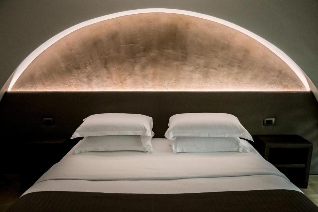 都灵ARCADIAN suite&rooms的一张带拱门的床铺,配有两个枕头