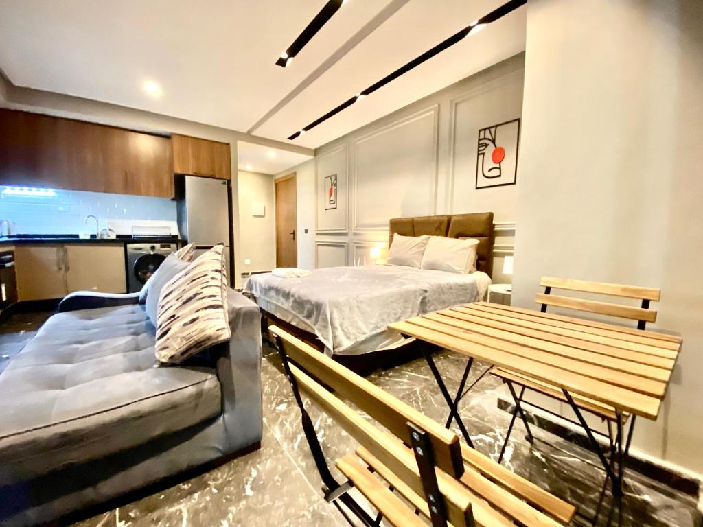 卡萨布兰卡Lovely 1-bedroom rental unit near 2mars/Habous的一间卧室配有一张床、一张桌子和一张沙发