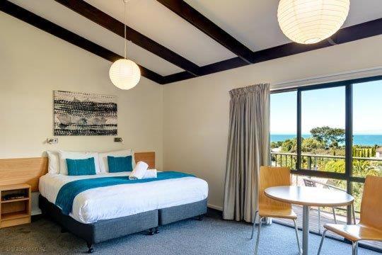 凯特里特里Unit 6 Kaiteri Apartments and Holiday Homes的一间卧室配有一张床,享有海景