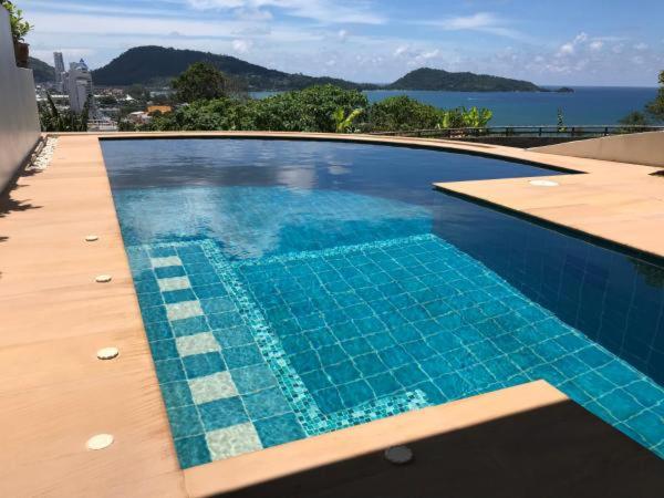 芭东海滩Andaman Hill Pool Seaview的蓝色的游泳池,享有水景