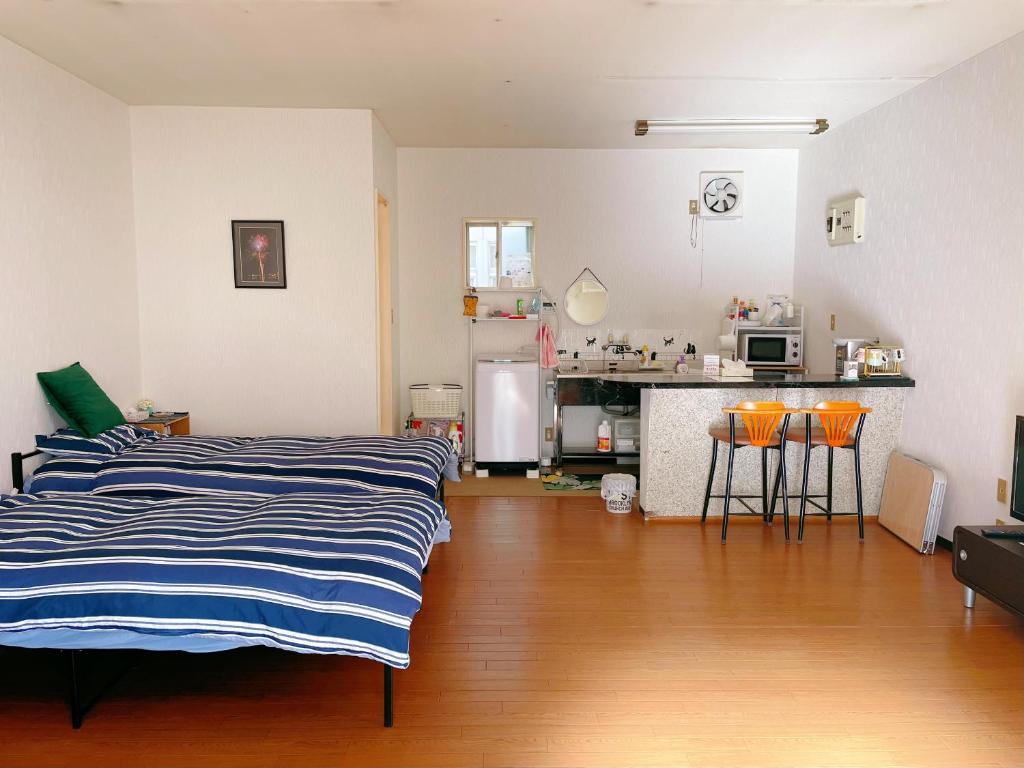 甲府富竹民泊的一间带两张床的客厅和一间厨房