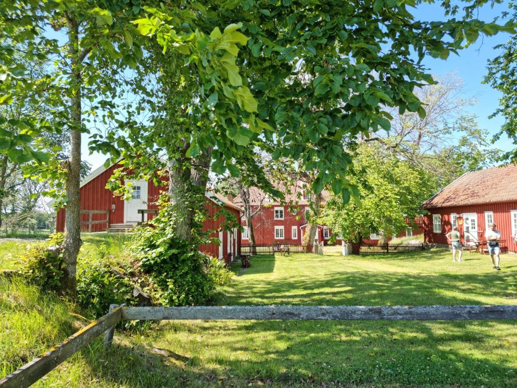 埃勒斯Kobbar & Skär Vandrarhem的红谷仓,有树和栅栏