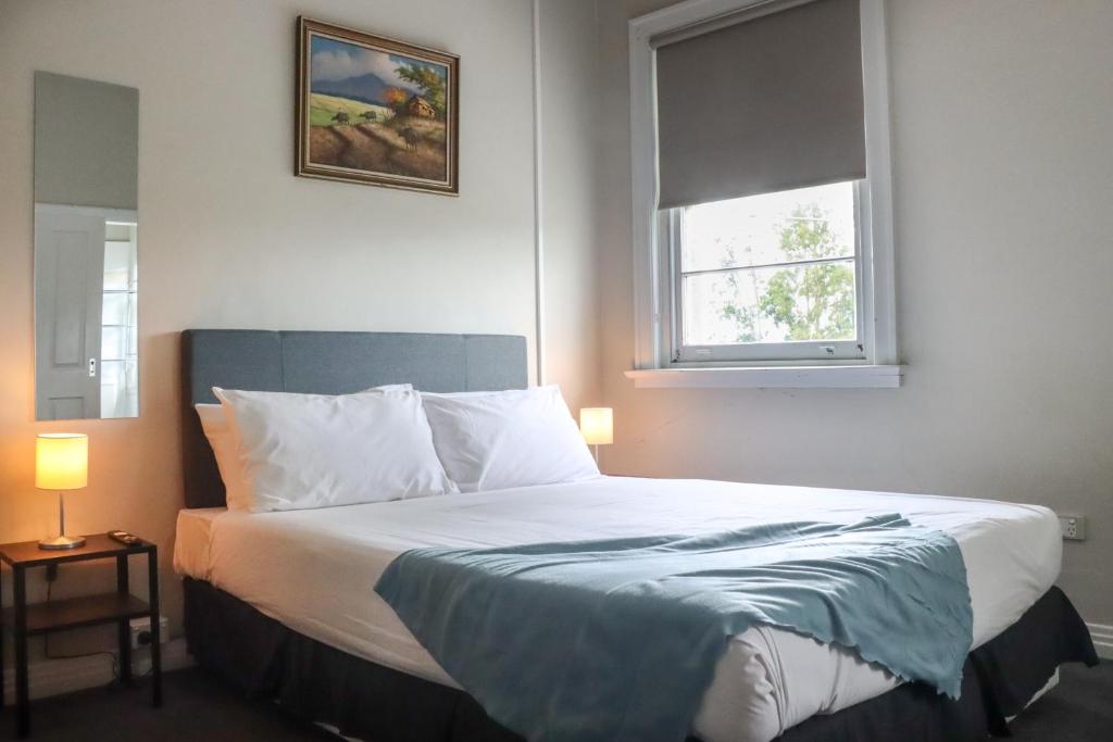 温莎Tates Hotel Windsor的一间卧室配有一张带蓝色毯子的床