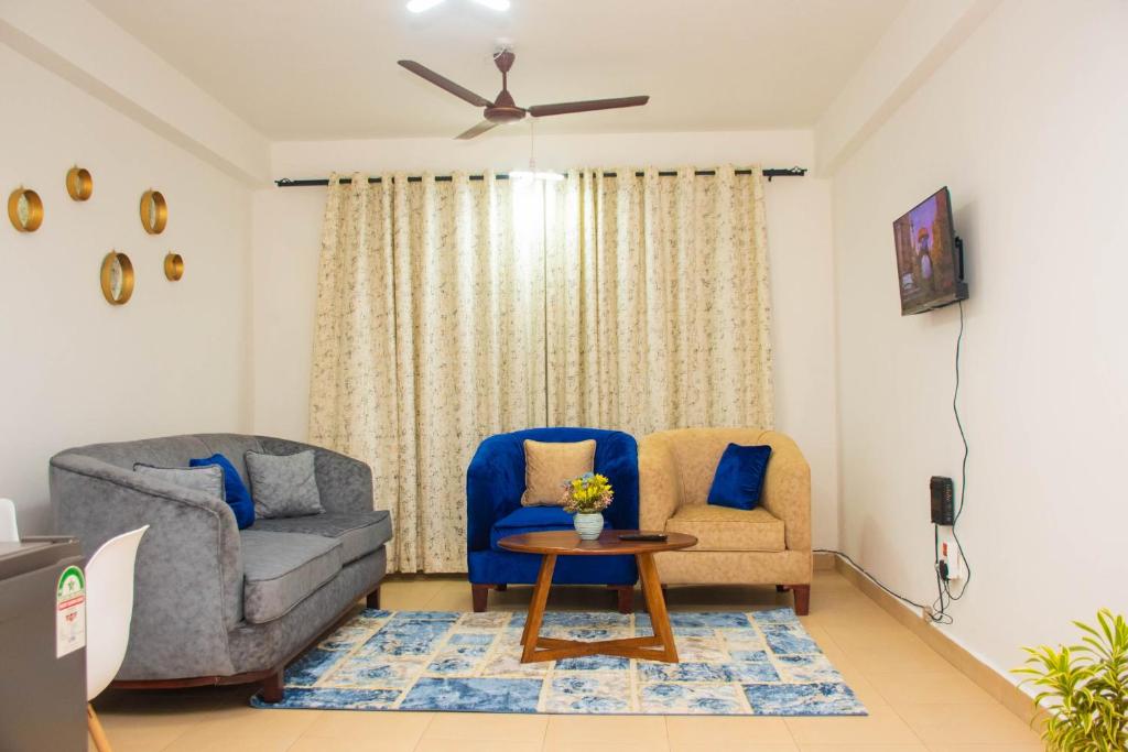 蒙巴萨IWACU-Cosy,Spacious 1 Bedroom Apartment along Nyali Road的客厅配有沙发、椅子和桌子