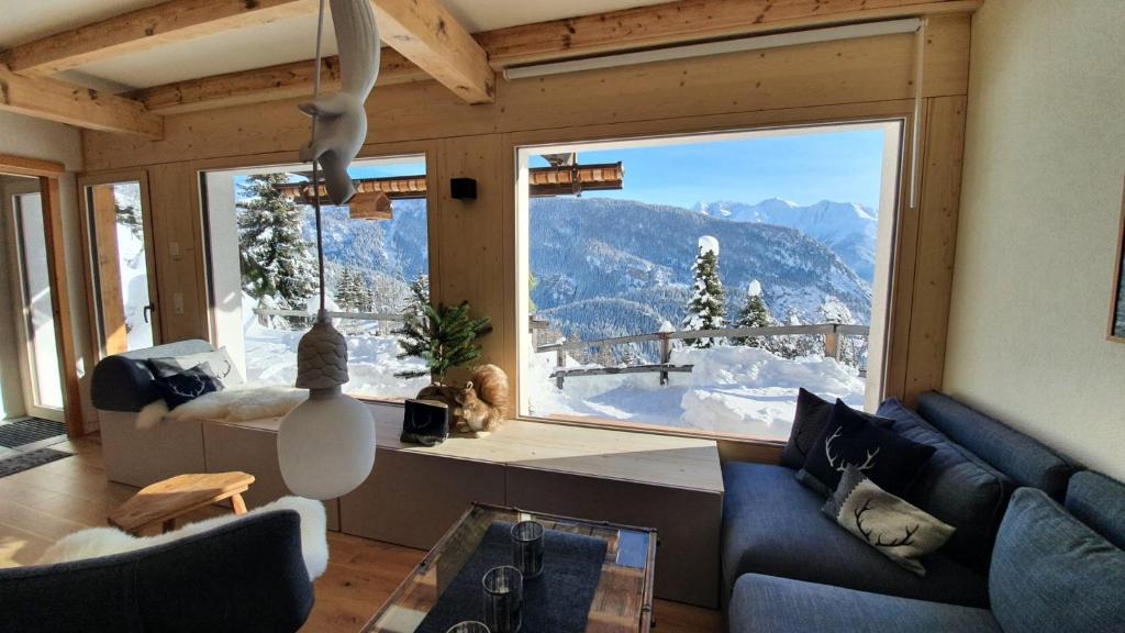 布拉腾Chalet Baumfuchs direkt an der Talabfahrt Belalp的客厅设有山景大窗户