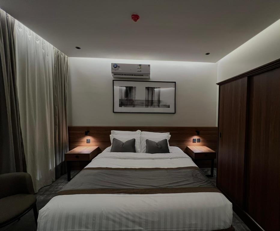 艾卜哈سيفن سون للأجنحة الفندقية的一间卧室配有一张大床、两个床头柜和两盏灯。
