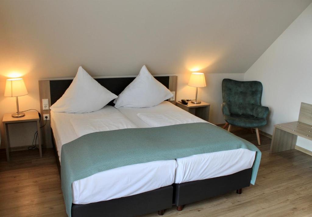 梅德巴赫特洛尔布奥豪斯酒店的一间卧室配有一张床和一把绿色椅子