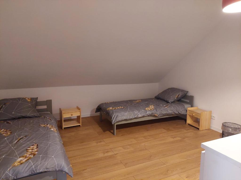 克拉科夫Pokoje Kraków Tyniec的一间卧室设有两张床,铺有木地板