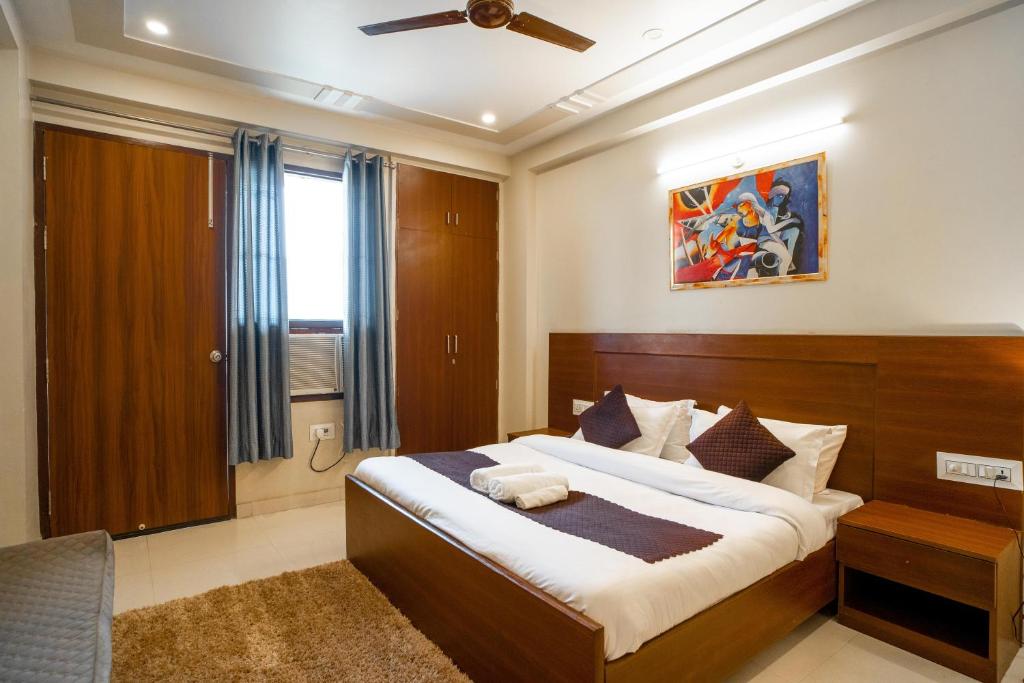 古尔冈The Lodgers 2 BHK Serviced Apartment infront of Artemis Hospital Gurgaon的一间卧室设有一张大床和一个窗户。