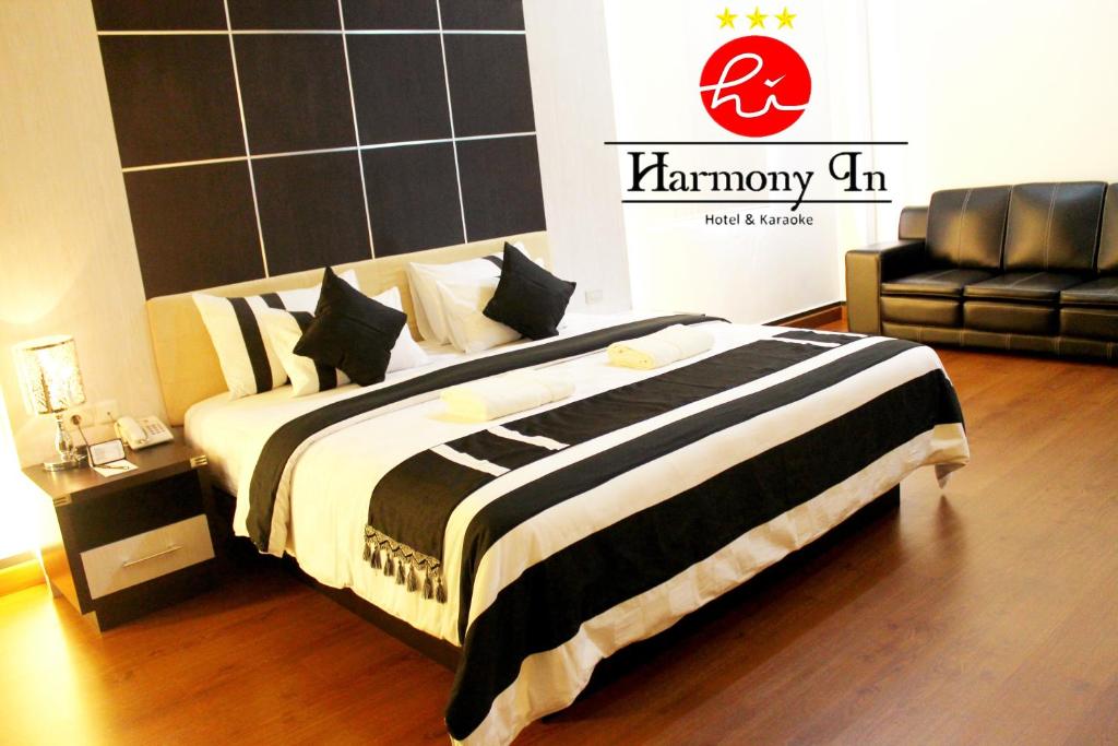 坤甸哈默尼酒店和卡拉OK的一间卧室配有一张带黑白毯子的床