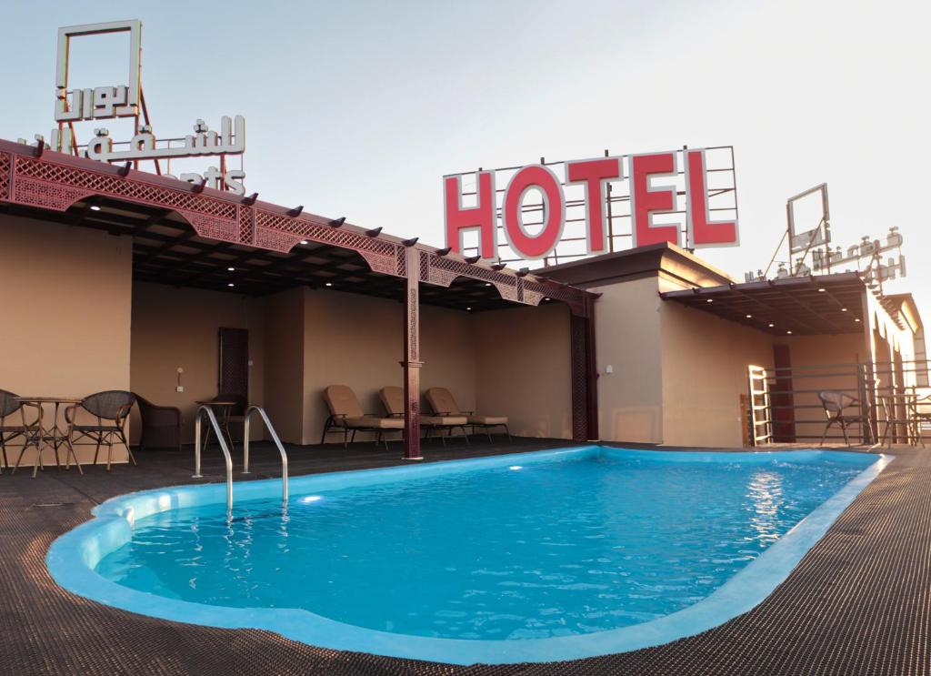 尼兹瓦Ewann Hotel Apartments的酒店前方设有游泳池的酒店