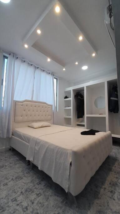 阿劳卡Apartamento Las Palmas的白色卧室配有一张带白色窗帘的大床