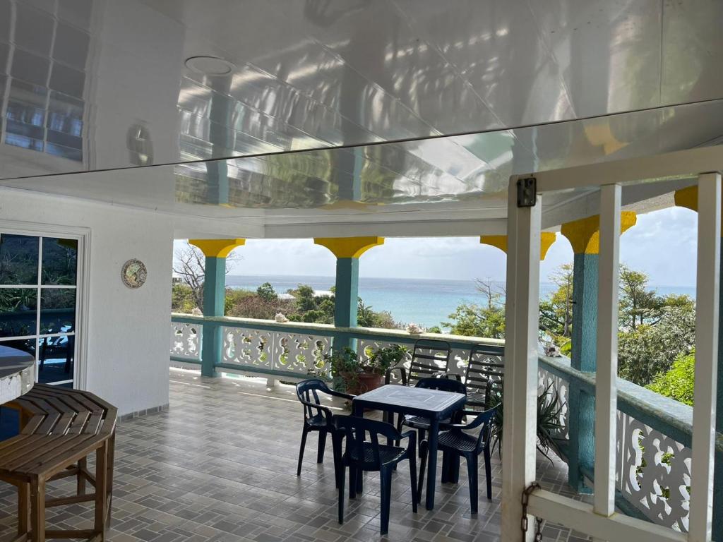 普罗维登西亚Posada buena vista al mar的一个带桌椅的海景阳台
