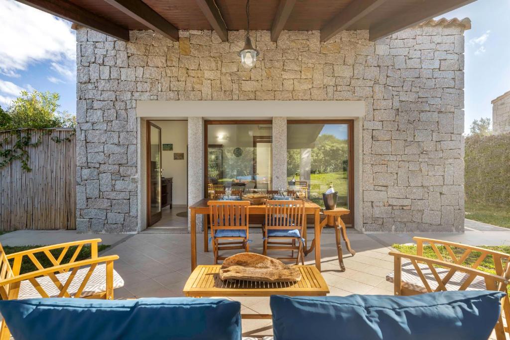 哥斯达雷Villa Sa Perda 3 - FREE WIFI - 500mt from the beach的一个带桌椅和石墙的庭院