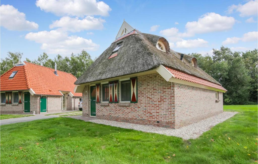 IJhorst3 Bedroom Gorgeous Home In Ijhorst的一块旧砖砌的建筑,在田野上拥有茅草屋顶