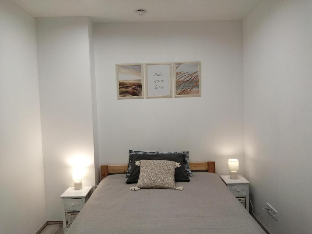 利耶帕亚PortStreet apartamenti的一间卧室配有一张带2个床头柜和2盏灯的床。