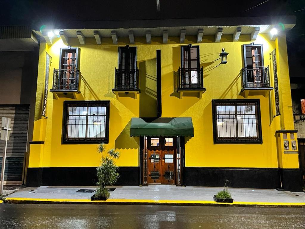 圣何塞20街精品酒店的黄色的建筑,设有门窗