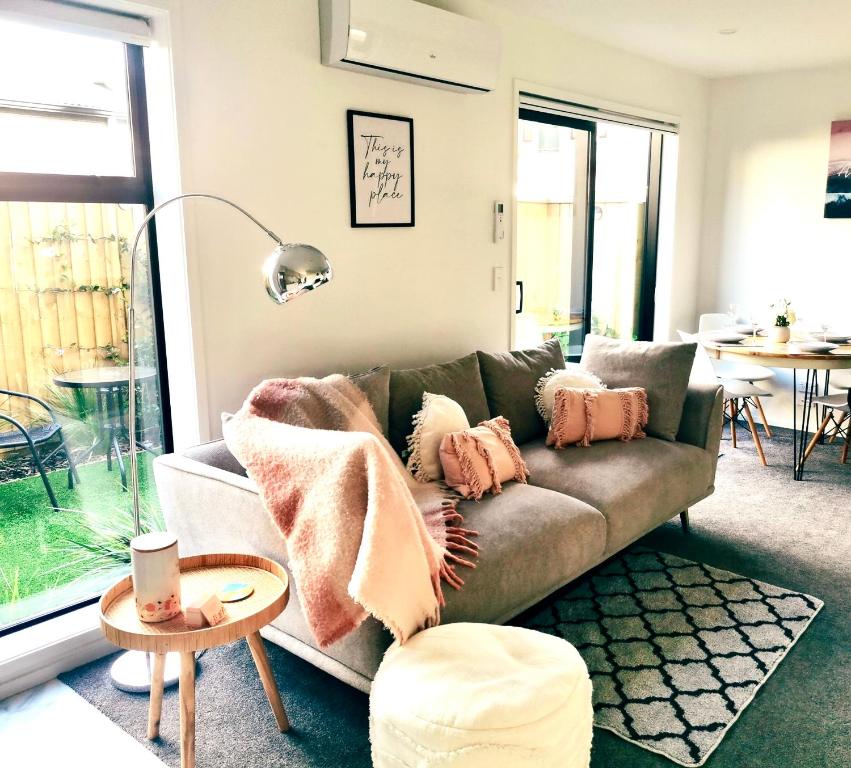 基督城Home sweet home Christchurch Centre的客厅配有带枕头的沙发