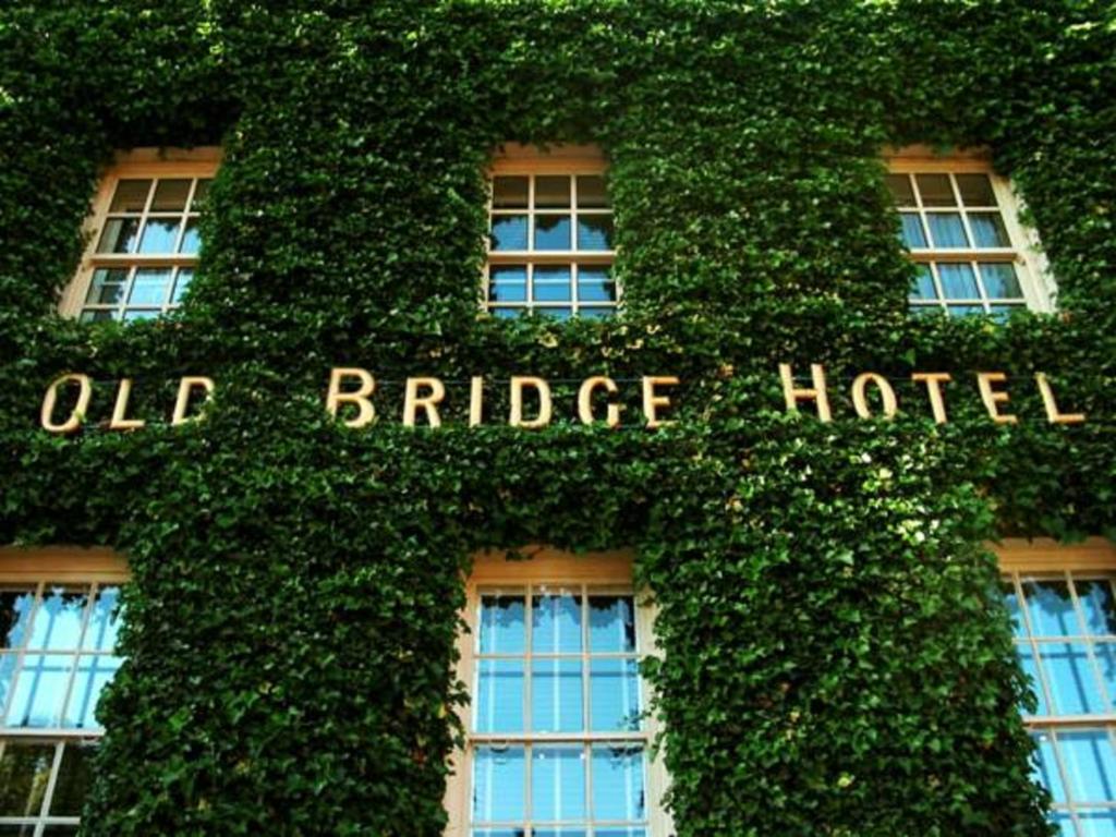 亨廷登奥德布里奇酒店的一座常春藤覆盖的建筑,上面写着旧桥酒店