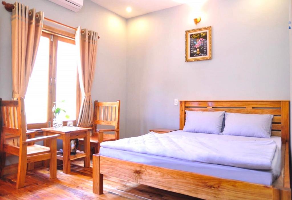 富国Liên tho Phú Quốc的卧室配有一张床和一张桌子及椅子