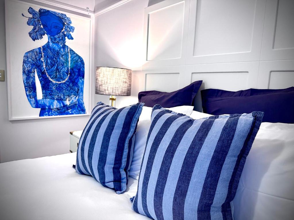 布里斯班Ciao Bella的一间卧室配有一张带蓝色和白色枕头的床