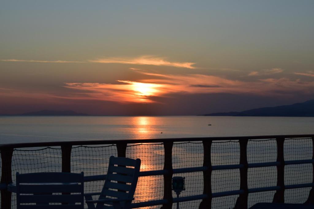 米克诺斯城米克诺斯景致酒店的船上两把椅子的日落
