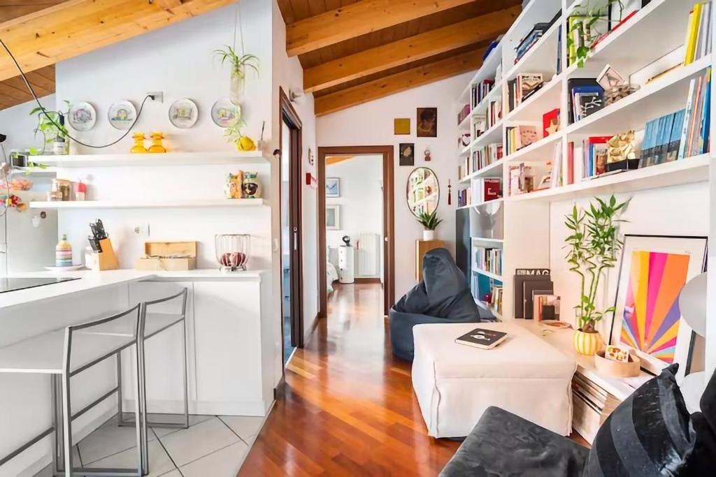 米兰Le Domus Milano_Attic with terrace的厨房以及带白色墙壁和木制天花板的客厅。