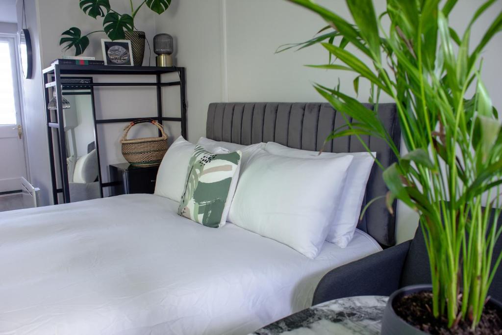 利特尔Annex By The Sea的一间卧室配有带白色枕头和植物的床