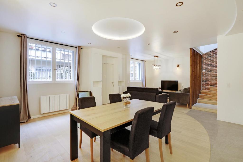 巴黎Pick A Flat's Apartment in La Chapelle - Impasse du Curé的用餐室以及带桌椅的起居室。