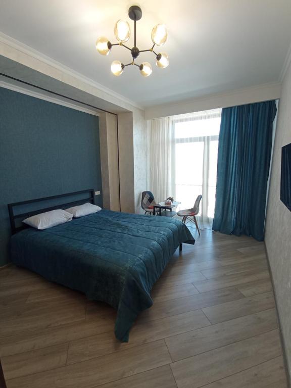 萨克德佐尔镇Alvina complex的一间卧室配有一张大床和一个吊灯。