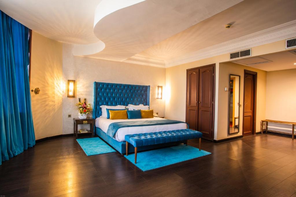 卡萨布兰卡乐尚尼枫Spa酒店的一间卧室配有一张特大号床和蓝色床头板