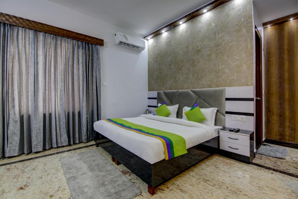 古尔冈Treebo Trend Sai Village Manesar的一间卧室设有一张床和一个大窗户