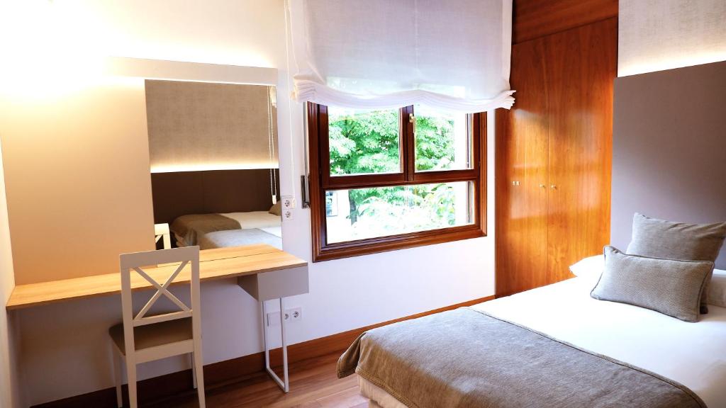 杜兰戈Hotel Ocamiño的一间卧室配有一张床、一张书桌和一个窗户。