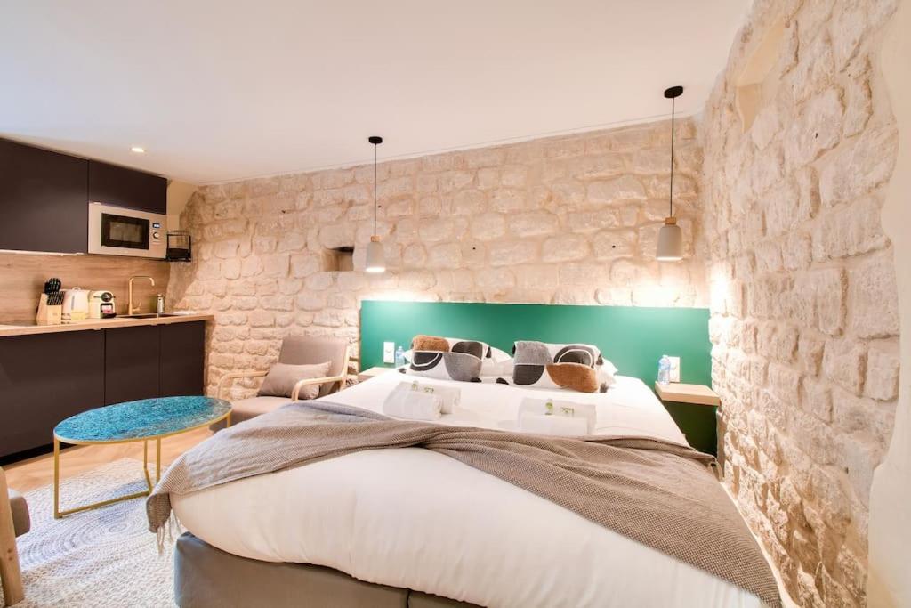 巴黎Magnifique studio au coeur de Montmartre的一间卧室设有一张大床和石墙