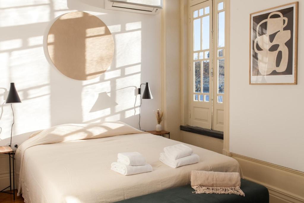 波尔图Alameda Suites - River Guest House的卧室配有白色床和毛巾