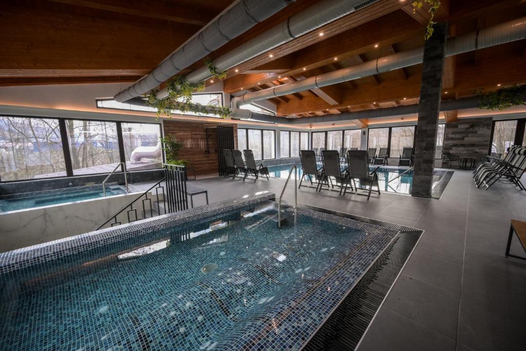 上维谢乌Hotel Yara的一座带桌椅的大型游泳池