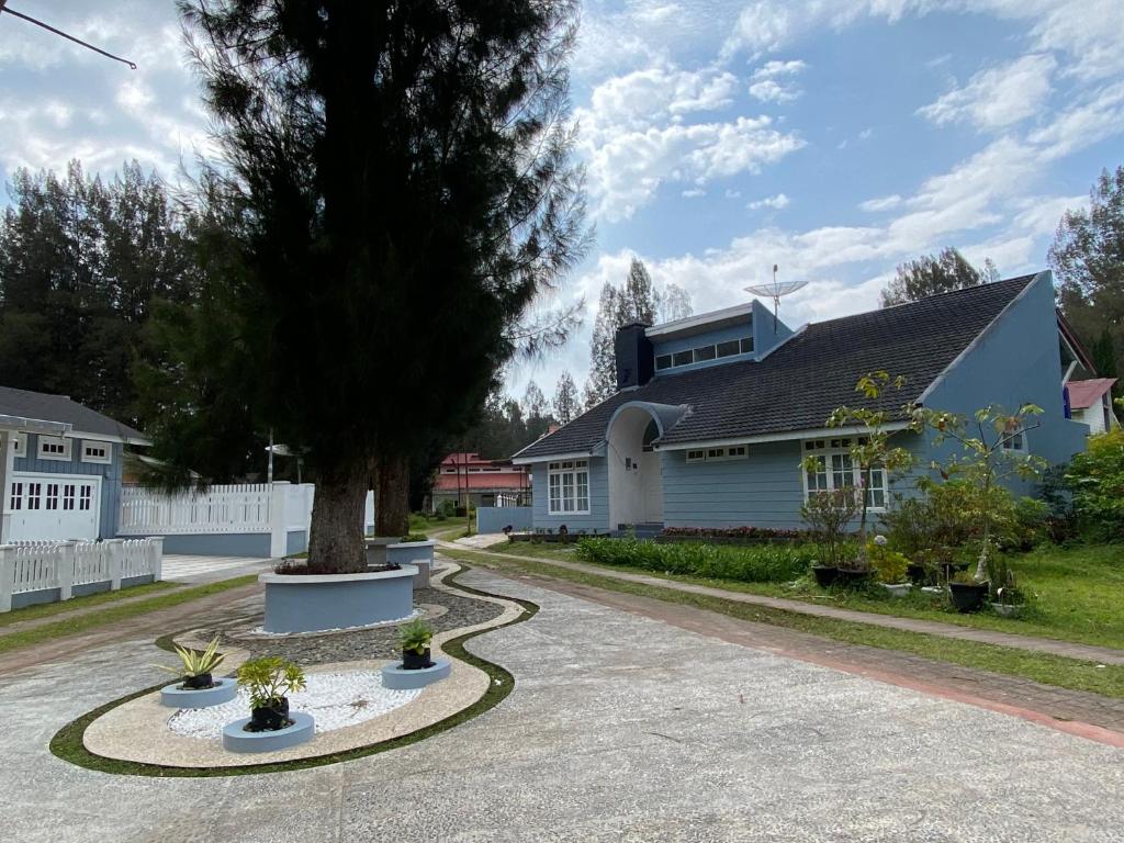 不拉士打宜Villa Berastagi Indah A17 - TEBU MANIS的车道中间有树的房子