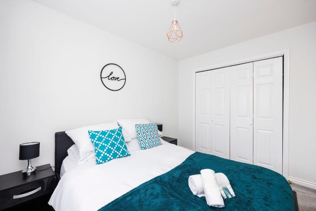 巴尔金Newly refurbished charming 3-Bed House in Barking的一间卧室配有一张床,上面有两条毛巾