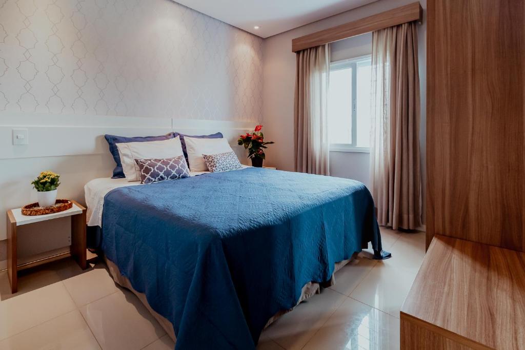 奥兰布拉Bloom Guesthouse的一间卧室配有一张带蓝色毯子的床和窗户。