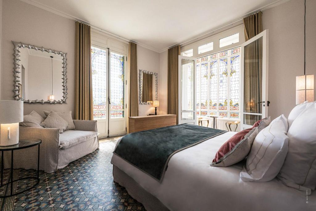 纳博讷Hôtel Le Mosaïque的一间卧室配有一张大床和一张沙发