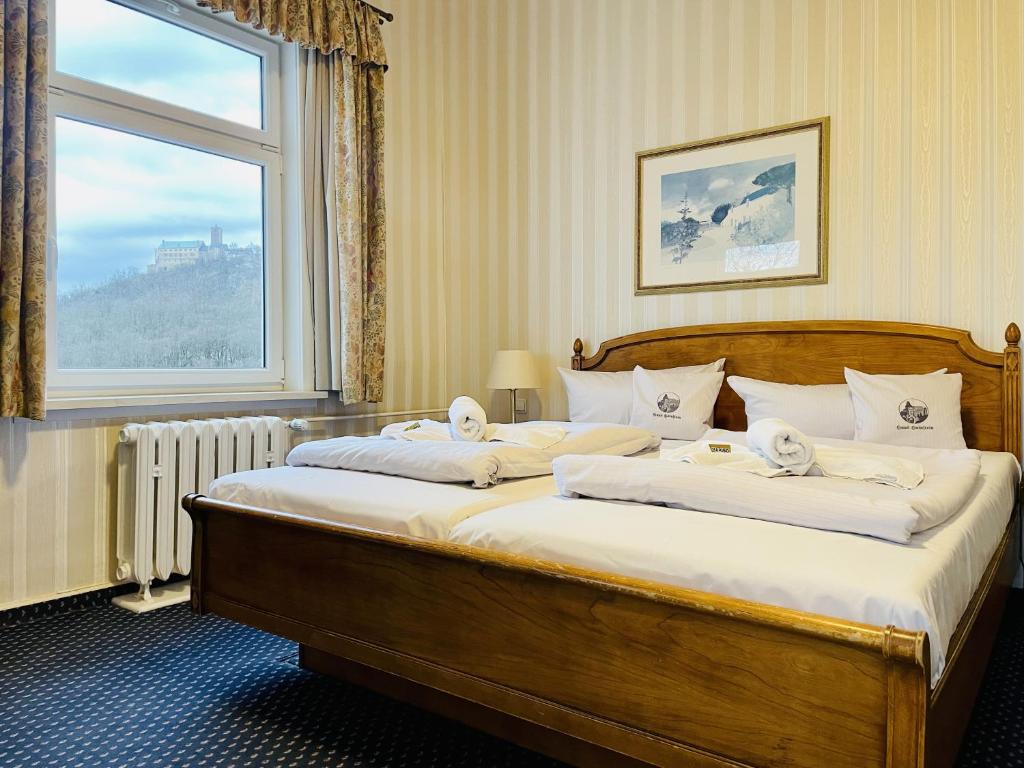 艾森纳赫翰斯海尼斯汀酒店的一间卧室设有一张大床和窗户