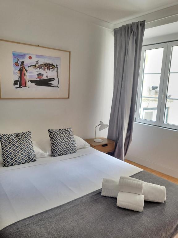 里斯本阿尔法玛服务公寓的卧室配有一张大白色床和窗户