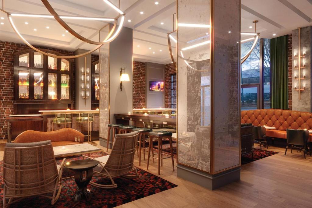 亚特兰大印迹珍品格伦酒店的一间带桌椅的餐厅和一间酒吧