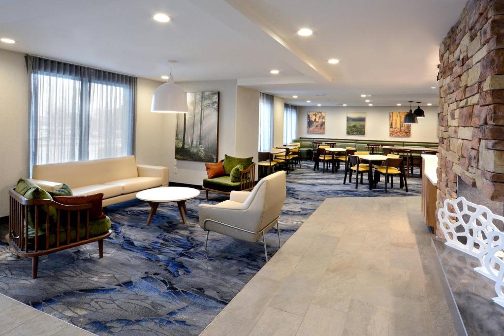格林斯伯勒格林斯博罗机场费尔菲尔德客栈的一个带沙发和椅子的大堂和一间用餐室