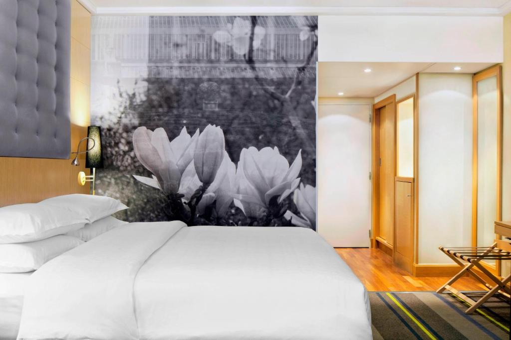 扎芬特姆布鲁塞尔机场喜来登酒店的卧室配有白色的床和黑白画作
