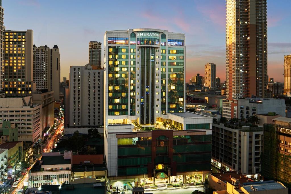 马尼拉Sheraton Manila Bay的享有夜间城市景观和建筑